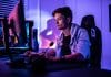 Writing A Video Game Walkthrough Article: 9 Ways To Make It Successful profile view of man sitting at desk bathed in purple light looking at computer screen