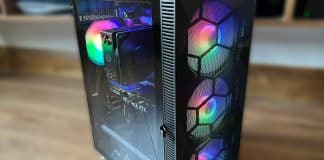 MONTECH X3 Mesh PC Case Review offset side view of MONTECH X3 Mesh pc case with rainbow lighted fans with a brown wood floor blurred background