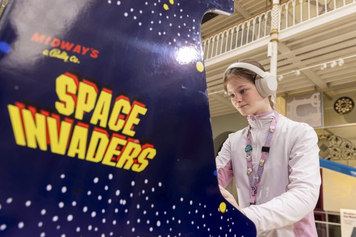 games exhibition girl plays retro arcade game Space Invaders