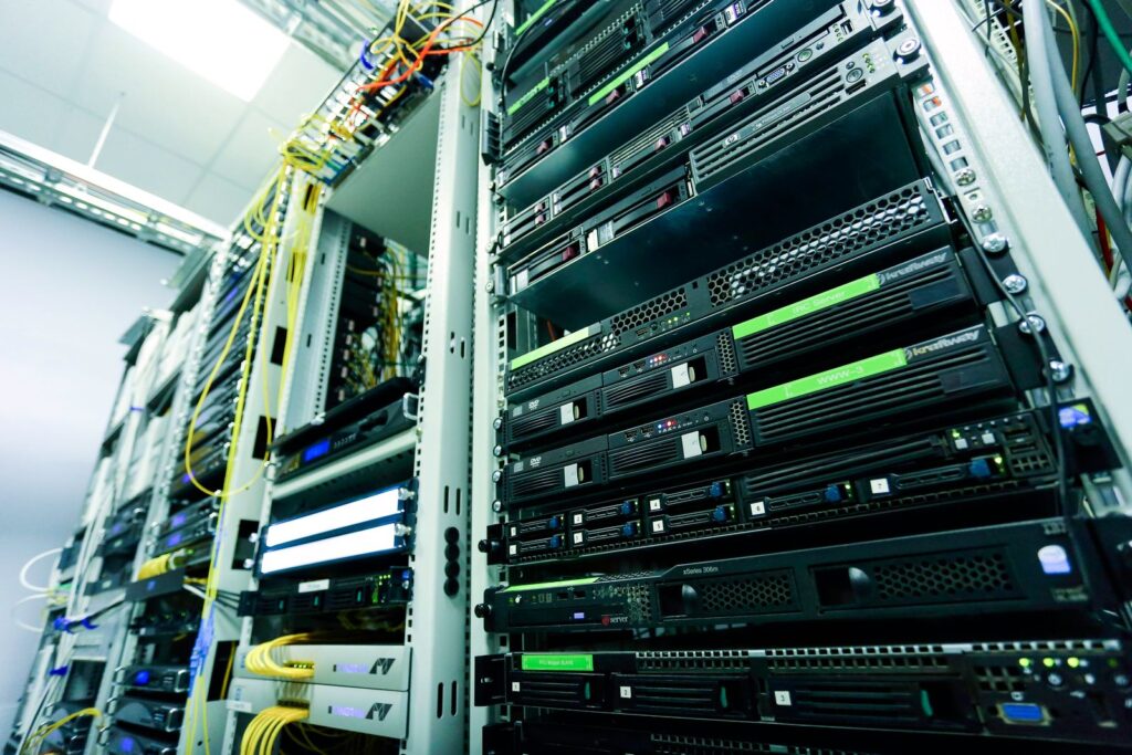 Rows of rack-mounted servers with yellow network cables in a data centre