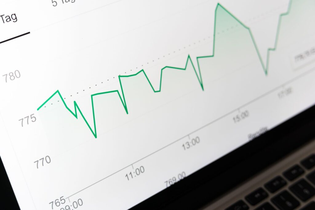 A green line chart on a laptop screen showing values rising and falling over time