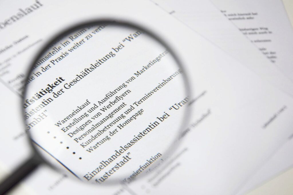 A magnifying glass enlarging lines of printed text on a business document