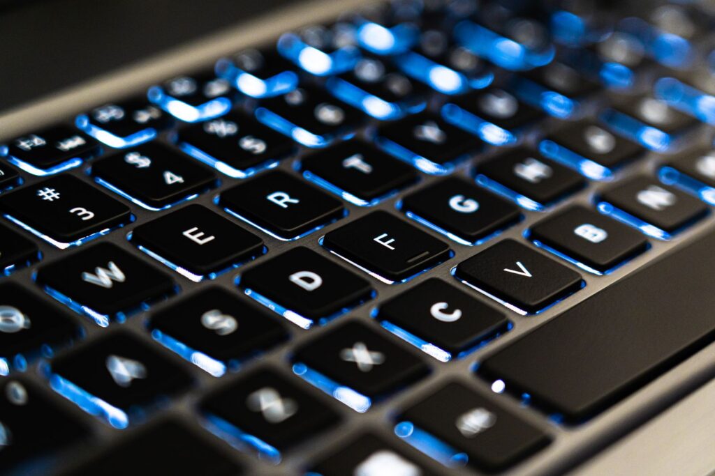 Close-up of a laptop keyboard with blue backlit keys