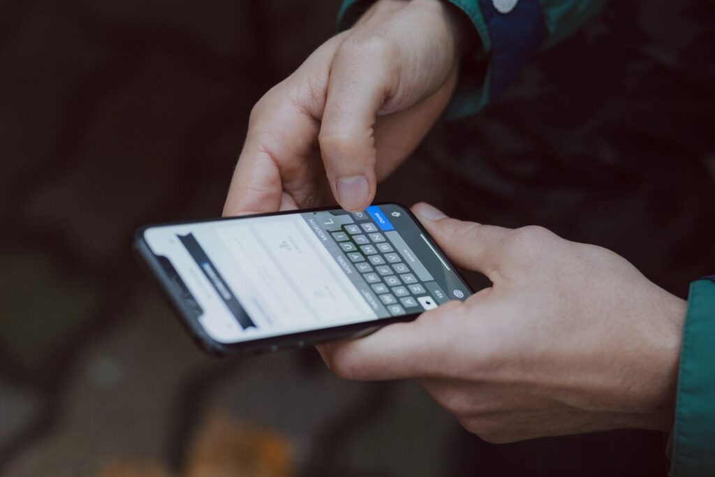Two hands typing into a form on a smartphone screen