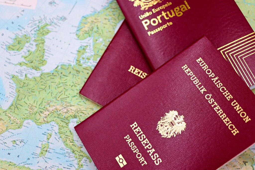 Two red European passports lying on a map of Europe