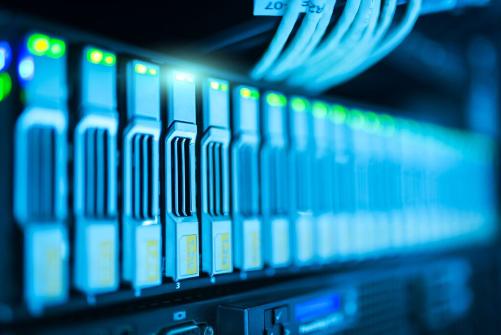 A row of server drives with glowing status lights in a data centre rack