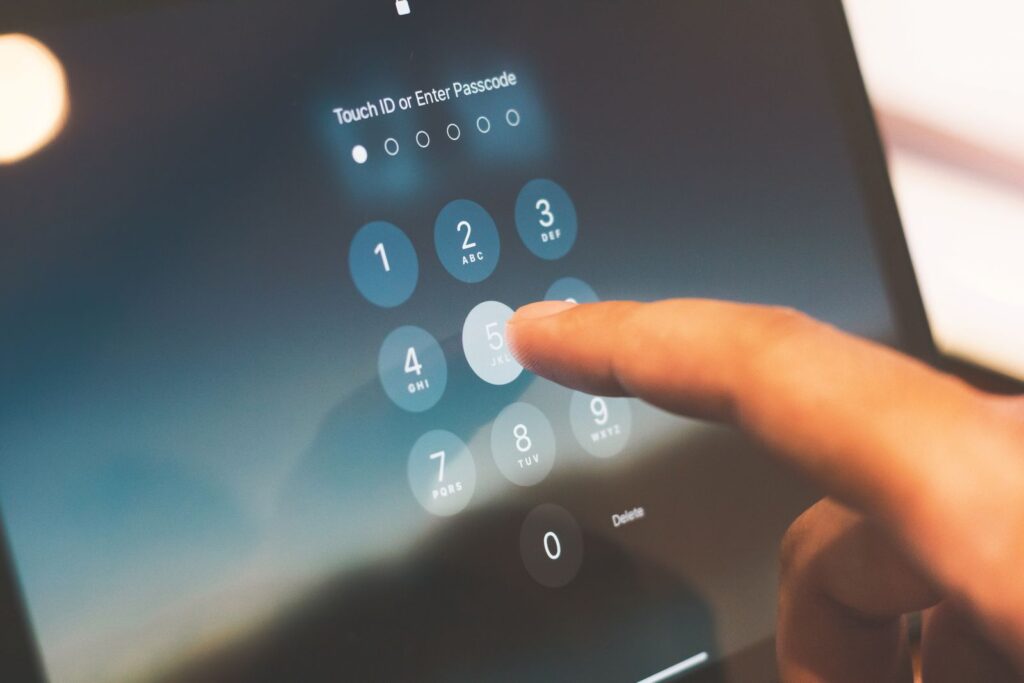 A finger entering a passcode on a touchscreen device