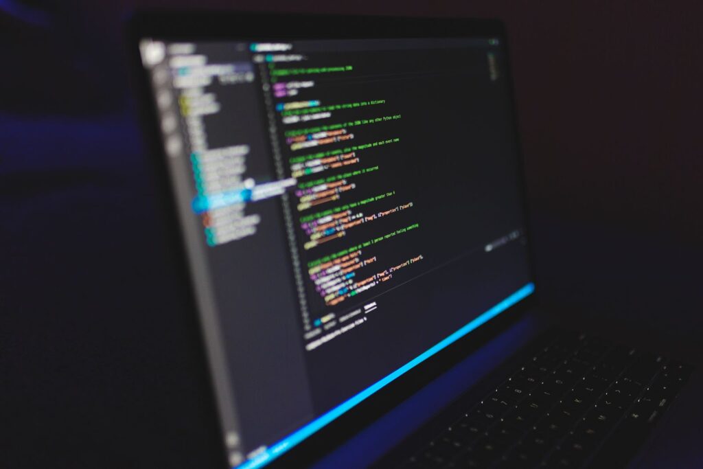 Lines of code displayed on a laptop screen in a dark room