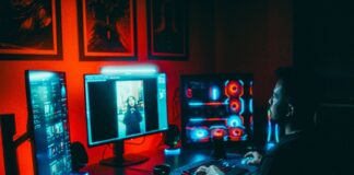 Valve admits Steam has an AI slop and clone problem but says it will not gatekeep PC desk with three monitors and a glowing custom gaming PC in a dark red lit room